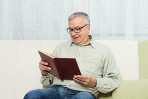 Senior man enjoys reading book. photo