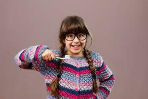 Happy little nerd girl  brushing teeth photo