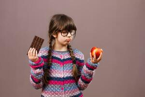 Little nerd girl wants eat chocolate rather then fruit photo