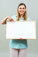 Beautiful nurse is pointing at whiteboard. photo