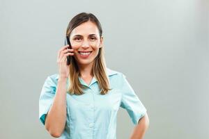 Beautiful nurse talking on mobile phone. photo