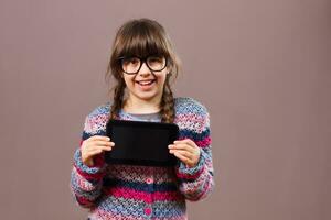 Little nerdy girl holding digital tablet photo