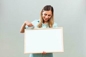 Beautiful nurse is pointing at whiteboard. photo