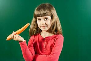 Little girl holding carrot photo
