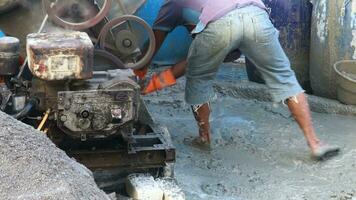 building materials. Construction workers take split stone mix with cement and black sand to build a house manually video