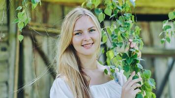 Russian girl posing by the branches of a birch tree. photo