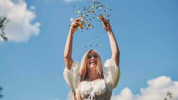 A girl tosses a confetti on a summer day and spins around. photo