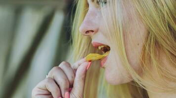 un niña comiendo papas fritas en un verano tarde. foto