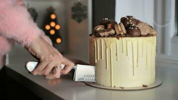 The girl cuts her freshly baked cake in white icing. photo