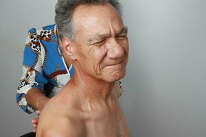 Older Mature Man having a massage on his upper back and neck for pain relief photo