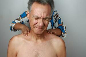 más viejo maduro hombre teniendo un masaje en su Superior espalda y cuello para dolor alivio foto