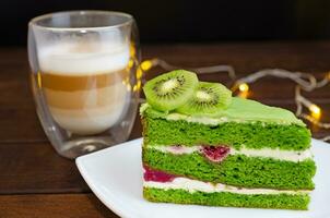Pistachio cake with kiwi, cream and raspberry filling and Cappuccino coffee photo