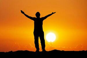 Silhouettes of men raising their hands in happiness and freedom on the mountain. photo