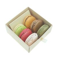 Tasty colorful macaroon in box paper on white background photo