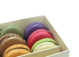 Tasty colorful macaroon in box paper on white background photo