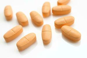 Orange pills over white background photo