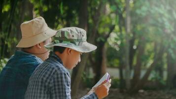 joven asiático Niños son utilizando un binocular a Estar atento para aves y animales en un local parque, suave y selectivo atención foto