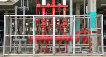 Red fire extinction pipes system in metal fences photo