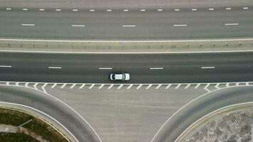 Top down aerial view of new highway high speed road intersections with few vehicles moving in the morning. video