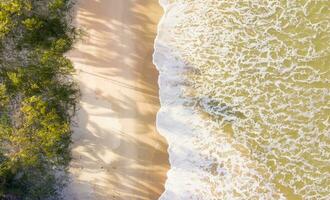 Aerial top view of sandy beach with stunning waves. photo