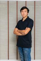 retrato de un hombre asiático en pie en negro camiseta y bermudas. aislado en antecedentes con Copiar espacio y recorte camino foto