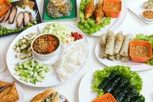 Assorted asian dinner, vietnamese food. Pho ga, pho bo, noodles, spring rolls, Nham due photo