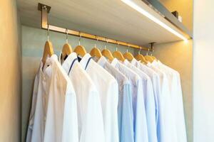 wardrobe with clothes hanging on rail photo