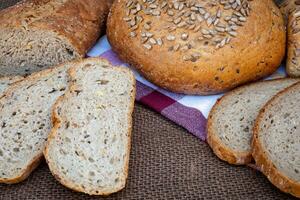 Fresh bread on table. Baked dark bread and sliced bread. photo