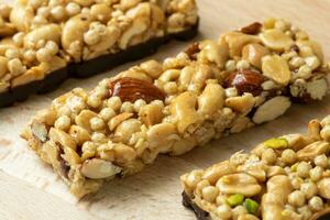 Cereal superfood energy bars with almond nuts, dry fruits, raisins chocolate on the wood table photo