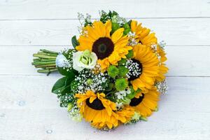 Wedding bouquet of sunflower on a wooden background. Top view with copy space. photo