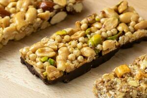 Cereal superfood energy bars with almond nuts, dry fruits, raisins chocolate on the wood table photo