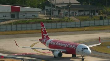 PHUKET, THAILAND FEBRUARY 19, 2023 Plane Airbus A320 of AirAsia taxiing at Phuket airport, side view. Low cost airline in Asia video