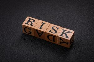 The inscription risk with wooden cubes on a dark concrete background photo