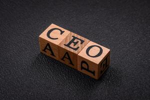 The inscription ceo in wooden cubes on a dark concrete background photo