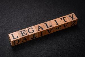 The inscription legality on wooden cubes on a dark concrete background photo