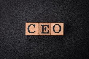 el inscripción CEO en de madera cubitos en un oscuro hormigón antecedentes foto