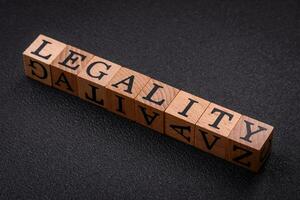 The inscription legality on wooden cubes on a dark concrete background photo