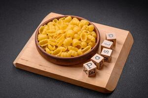 Raw durum wheat gnocchi pasta with salt and spices in a ceramic plate photo