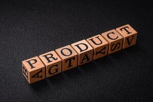 The inscription product with wooden cubes on a dark concrete background photo