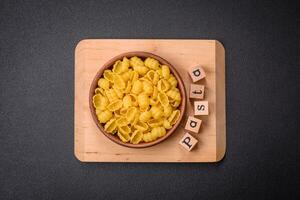 Raw durum wheat gnocchi pasta with salt and spices in a ceramic plate photo