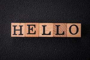 The inscription hello on wooden cubes on a dark concrete background photo