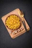 Raw durum wheat gnocchi pasta with salt and spices in a ceramic plate photo