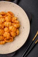 Delicious fresh pasta with pesto sauce, salt, spices and herbs on a ceramic plate photo