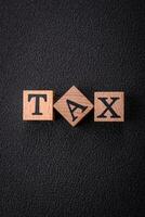 The inscription tax on wooden cubes on a dark concrete background photo