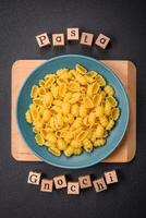 Raw durum wheat gnocchi pasta with salt and spices in a ceramic plate photo