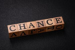 The inscription chance or change with wooden cubes on a dark concrete background photo