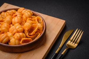 Delicious fresh pasta with pesto sauce, salt, spices and herbs on a ceramic plate photo