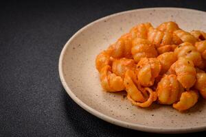 Delicious fresh pasta with pesto sauce, salt, spices and herbs on a ceramic plate photo