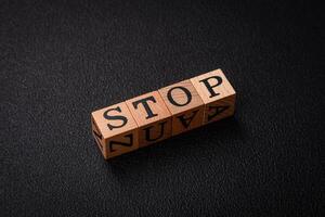 The inscription stop on wooden cubes on a dark concrete background photo