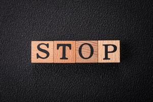 The inscription stop on wooden cubes on a dark concrete background photo